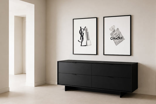 Framed black-and-white artworks in a calm contemporary interior with a black console